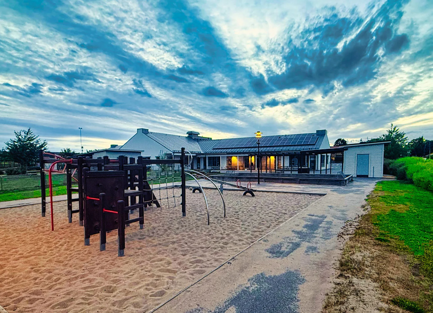 Förskola med lekställning och sandlåda i kvällsljus i Trosa kommun